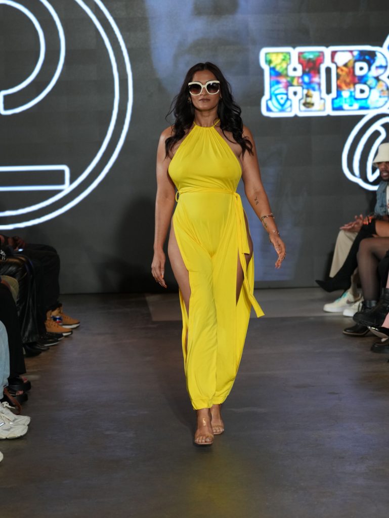 Fatima Ali wears a yellow jumpsuit by Phillip Loving - Photo Credit Paradigm Photography - All Rights Reserved